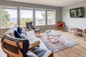 a living room with a couch and chairs and windows at Just Beachy 101 in Yachats