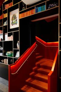 a library with a red staircase with bookshelves at citizenM Washington DC Capitol in Washington, D.C.