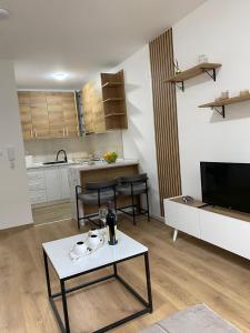 a living room with a table and a kitchen at Vasiljević Apartman Koviljača in Banja Koviljača
