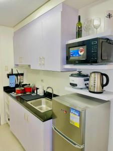 a kitchen with a sink and a microwave at ASV Condo Staycation SMDC Breeze in Manila