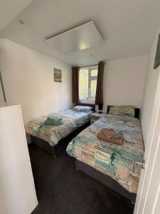 a bedroom with two beds and a window at Seagulls Rest in Isle of Wight