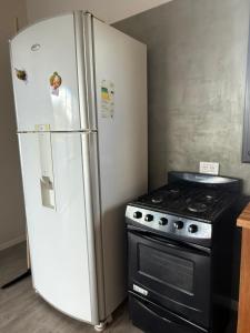 a refrigerator in a kitchen next to a stove at Abril, alquiler temporario in Piñero
