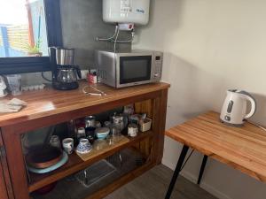 a microwave sitting on top of a wooden table at Abril, alquiler temporario in Piñero