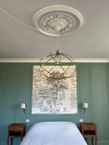 Un dormitorio con una cama y una lámpara de araña en Manoir de Salleviale, en Conques-en-Rouergue 4 fotos más