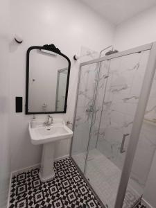 Un baño con lavabo y ducha con espejo. en Manoir de Salleviale, en Conques-en-Rouergue