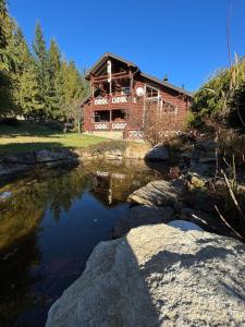 a brick house with a pond in front of it at Villa Anna in Guta