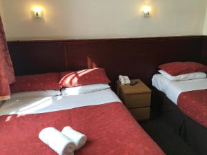 two beds in a hotel room with red and white towels at Smiths Hotel in Glasgow