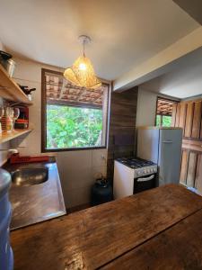 a kitchen with a sink and a refrigerator and a window at Loft Iemanjá in Itacaré