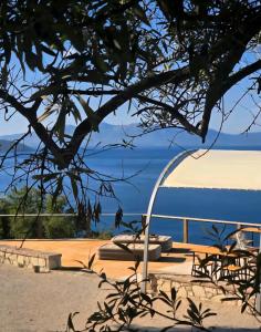 Blick auf einen Strand mit einem Tisch und Bänken in der Unterkunft Cimarte The Path Lukove in Lukova