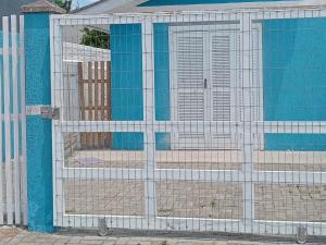 un cancello di fronte a un edificio con pareti blu di Aluguel casa azul a Capão da Canoa Altre 5 foto