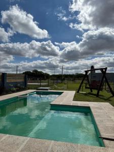 a swimming pool with a swing and a playground at Abril, alquiler temporario in Piñero