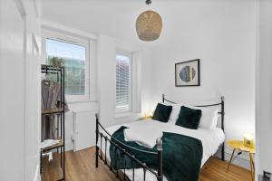 een slaapkamer met een bed en twee ramen bij 92 High Street in Carnoustie