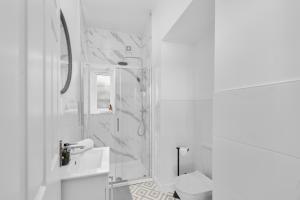 een witte badkamer met douche en toilet bij 92 High Street in Carnoustie +41 foto's