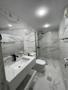 a white bathroom with a toilet and a sink at Spirit of the Badia camp in Disah