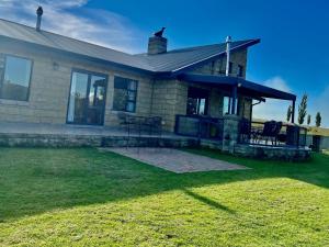 a house with a patio and a grass yard at De Krantz 6 Estate in Clarens