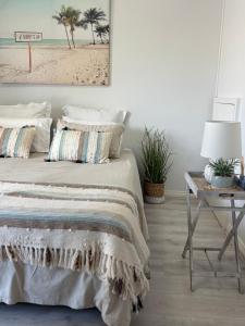 ein Schlafzimmer mit einem Bett und einem Tisch mit einer Lampe in der Unterkunft U2 at Moana Beach Esplanade - Exclusive 2 Bdrm Apt - WiFi - Spa - Pet Friendly in Moana