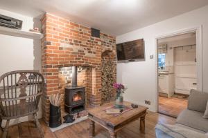 a living room with a brick fireplace at Charming Georgian flint cottage in Bury Saint Edmunds