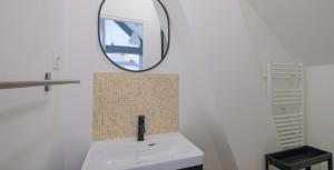 a bathroom with a sink and a mirror on the wall at Le Perchoir du marché - Appartement pour 2 personnes in Saint-Nazaire