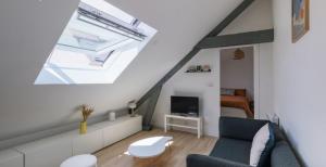 a attic living room with a couch and a bed at Le Perchoir du marché - Appartement pour 2 personnes in Saint-Nazaire