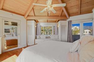 een slaapkamer met een wit bed en een plafondventilator bij Casa Azzurra in Santa Barbara +33 foto's