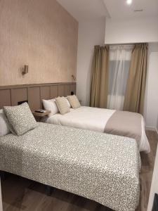 a hotel room with two beds and a window at ESTUDIOS BE RELAX Torrejon in Torrejón de Ardoz