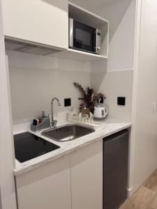a kitchen with a sink and a microwave at ESTUDIOS BE RELAX Torrejon in Torrejón de Ardoz