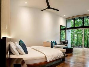a bedroom with a bed and a ceiling fan at Palmstone Retreat in Kitulgala +72 photos
