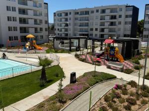 un parque con zona de juegos y piscina con tobogán en Jardines del Pacífico IV, en La Serena