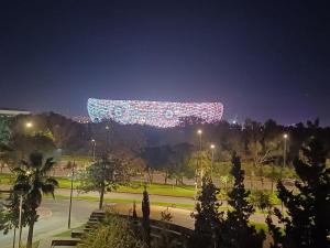 Una señal encendida en un parque por la noche en Spacieux et familial à 2 minutes à pied du stade de football de RABAT, en Rabat
