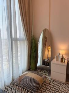a dressing room with a mirror and a pillow and a table at Beautiful studio at aljada community in Sharjah