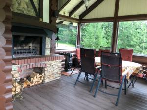 a screened in porch with a fireplace and a table and chairs at Villa Anna in Guta
