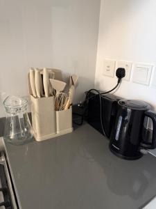 a kitchen counter with a knife block with utensils at Beautiful studio at aljada community in Sharjah