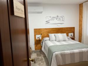 Un dormitorio con una cama con cabecero de madera. en Casa Rural Las Matillas, en Riópar