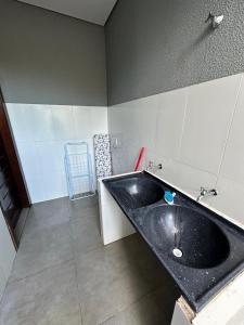 un baño con un lavabo negro en una habitación en Casa vaga 2 carros ou caminhonete, 2 quartos, espaçosa, completa para 8 pessoas, en Sinop 18 fotos más