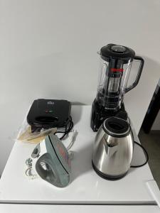 Una licuadora sobre un mostrador blanco con una tetera. en Casa vaga 2 carros ou caminhonete, 2 quartos, espaçosa, completa para 8 pessoas, en Sinop