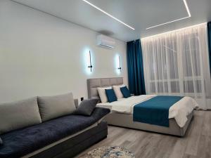 ein Schlafzimmer mit einem Bett und einer Couch in der Unterkunft Belvedere Apart 2, parking in Iwano-Frankiwsk