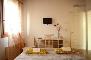 Cette chambre comprend un lit, une table et une télévision. dans l'établissement Agriturismo Dartora, à Sambruson