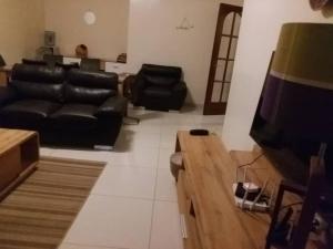 达喀尔MySuiteStays Keyless 3Bed Apt in Sacre Coeur的客厅配有黑色皮革家具和电视