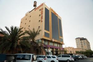 a building with cars parked in a parking lot at Ekono Hotel in Jeddah