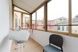 a room with a table and a chair and windows at BonB 127 c7-c8 in Padova