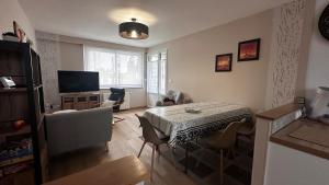 Una sala de estar con una mesa y sillas y un televisor. en 3 bedroom house for 5 people, en Rochefort
