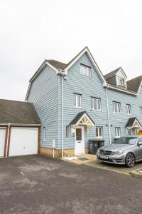 una grande casa blu con un'auto parcheggiata di fronte di Stunning 5 Bed Home in Maidstone a Snodland