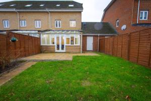 una recinzione di fronte a una casa con cortile di Stunning 5 Bed Home in Maidstone a Snodland Altre 21 foto