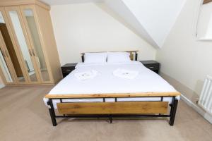 una camera da letto con un letto con lenzuola bianche di Stunning 5 Bed Home in Maidstone a Snodland