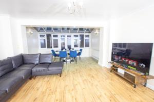 un soggiorno con divano e tavolo con sedie blu di Stunning 5 Bed Home in Maidstone a Snodland