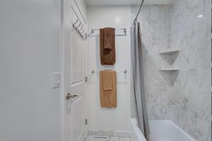 a white bathroom with a shower and a sink at 2BR DOG-Friendly Apt in 2-Fam Home - Comfy Retreat in Boston +19 photos