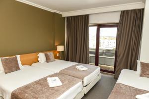 Ένα ή περισσότερα κρεβάτια σε δωμάτιο στο Dom Joao Hotel