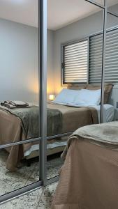 Beautiful apartment in Vila da Serra في نوفا ليما: غرفة نوم بها سريرين ومرآة +33 صورة