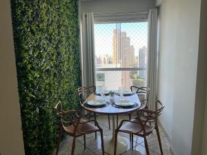 Beautiful apartment in Vila da Serra في نوفا ليما: طاولة وكراسي في غرفة بها نافذة