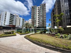 Beautiful apartment in Vila da Serra في نوفا ليما: ممشى في مدينة ذات مباني طويلة